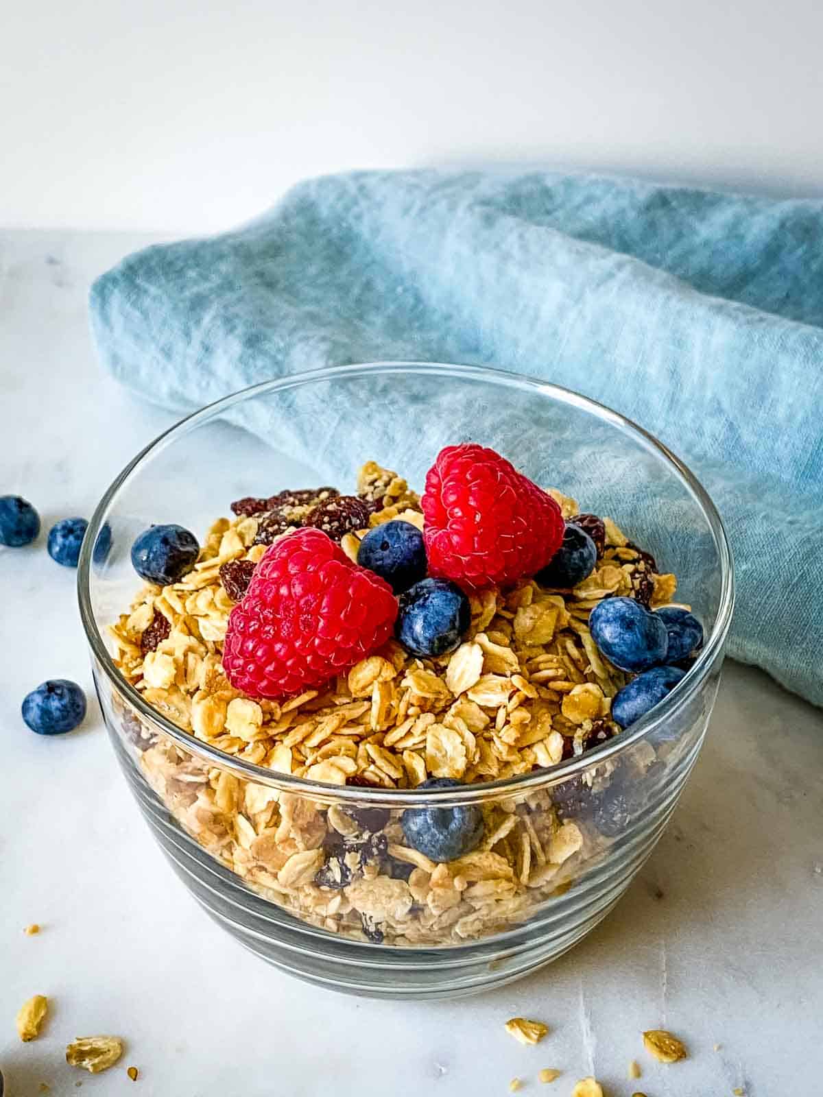A bowlful of homemade honey granola with berries on top.