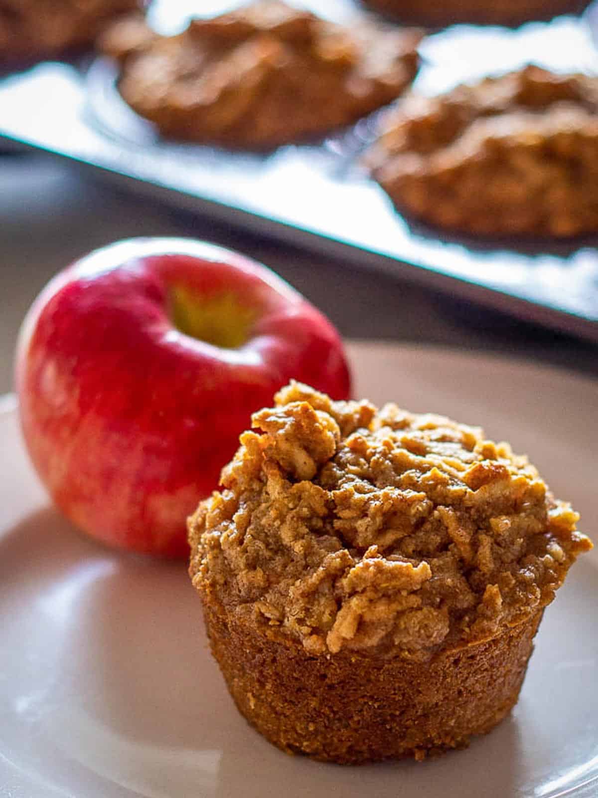 Baked Gluten Free Apple Muffin on a plate with apple.