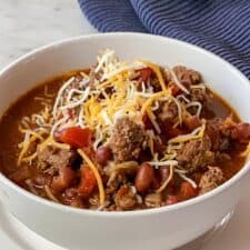 Bowl of Ground Bison Chili Recipe with a navy colored napkin in upper right corner.