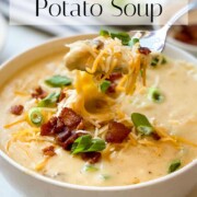 A bowl of The Best Potato Soup with Bacon show with various toppings.