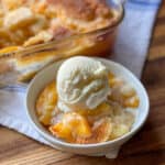 Bowl of Peach Cobbler with vanilla ice cream on top.
