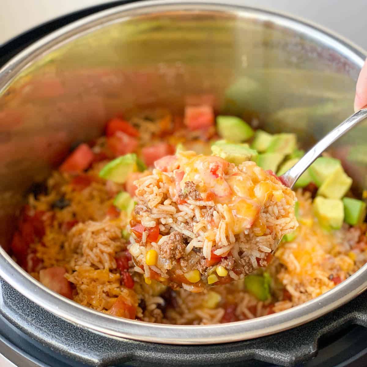 Spoonful of Instant Pot Mexican Casserole being raised out of the instant pot.