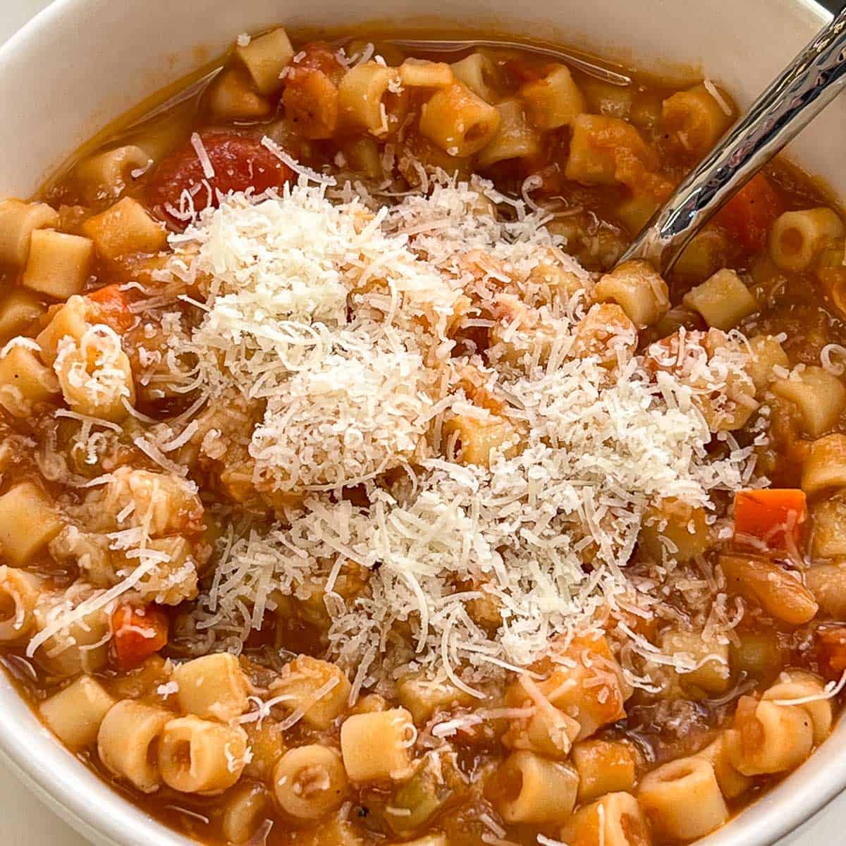 Image of a bowl of Pasta Fagioli with a hunk of bread.