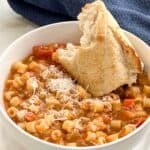 Image of a bowl of Pasta Fagioli with a hunk of bread.