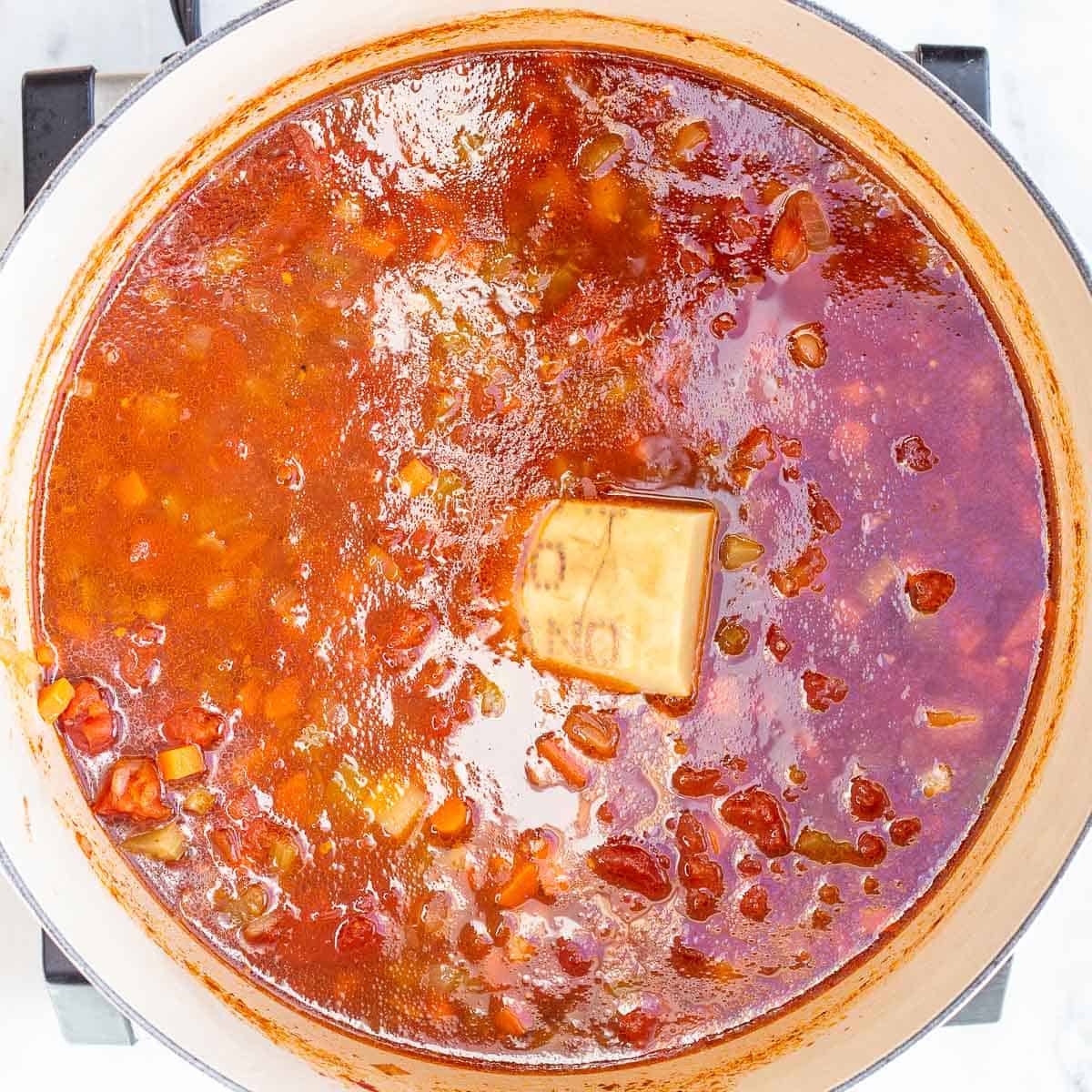 Image showing parmesan rind set into of a pot of Pasta Fagioli Soup.