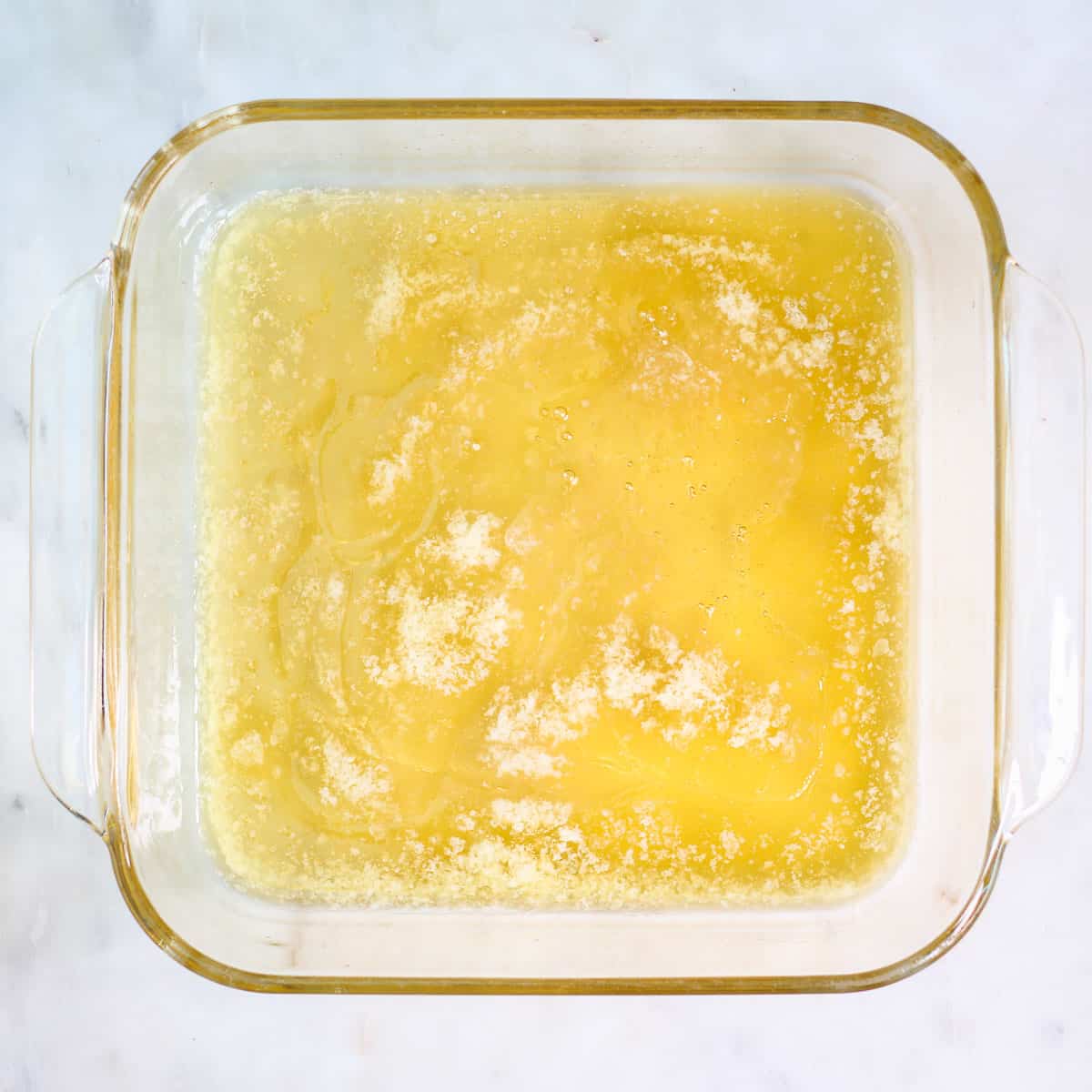 Honey on top of melted butter in pyrex baking dish.