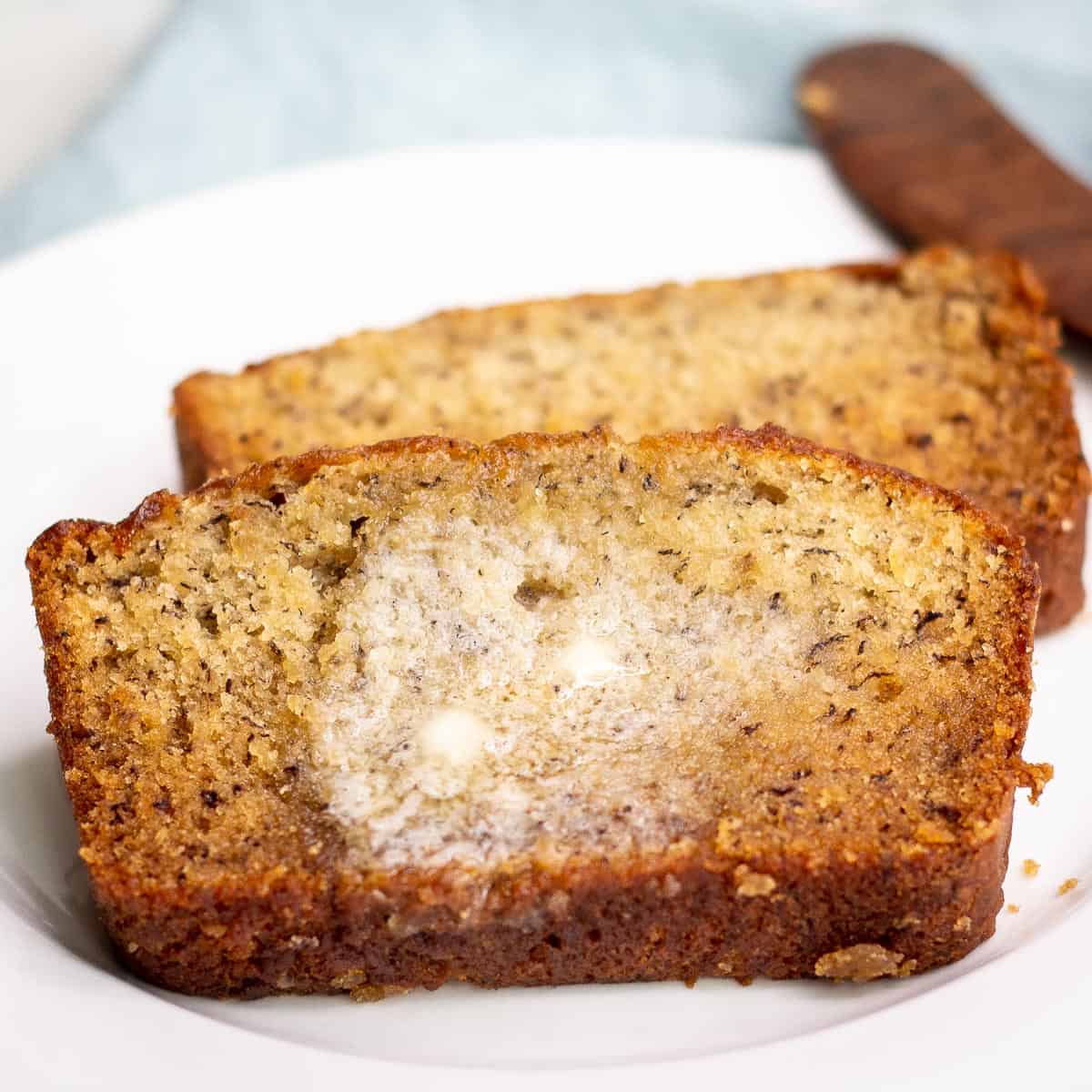 Sliced banana bread with melted butter on top.