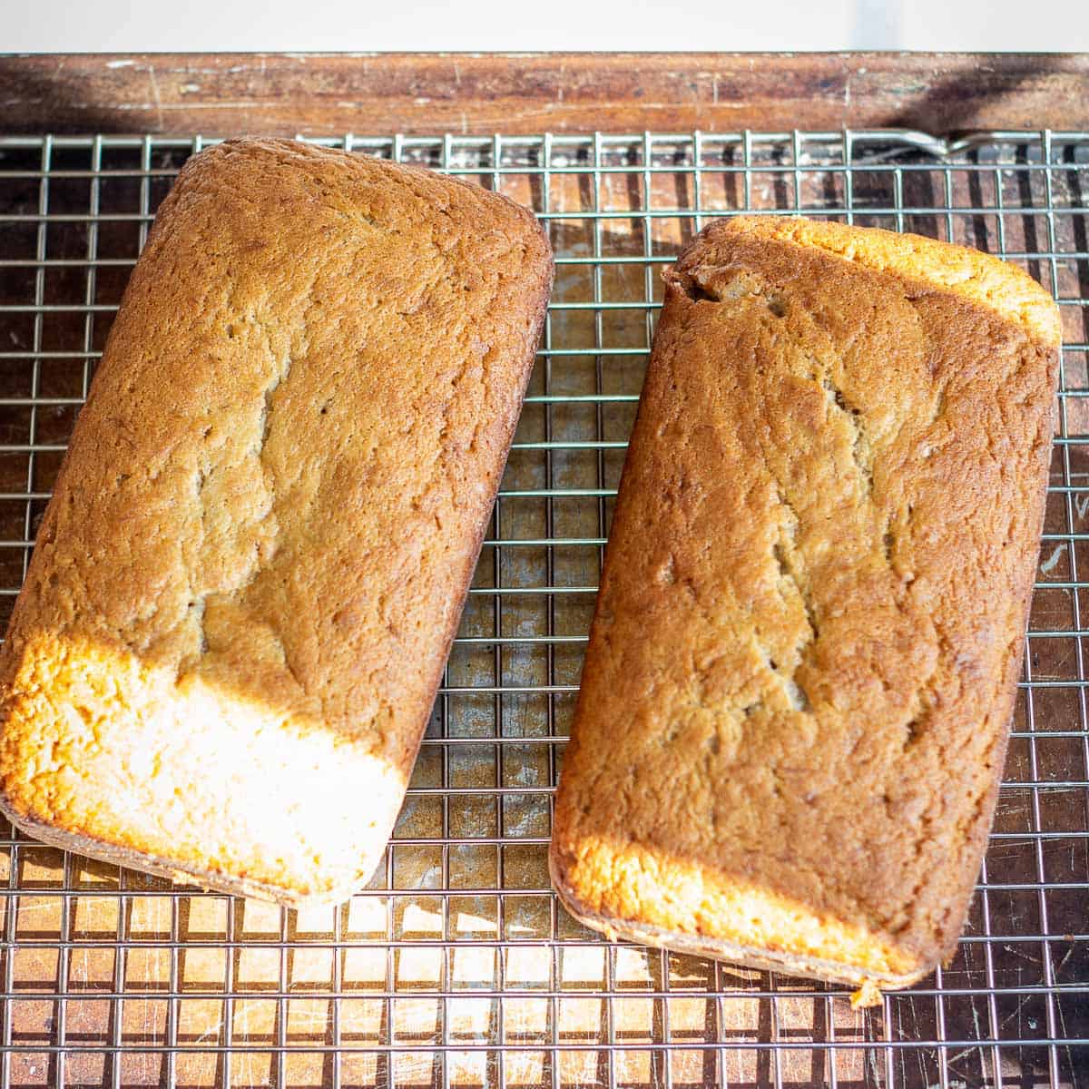 Freshly baked banana bread set to cool on wire rack.
