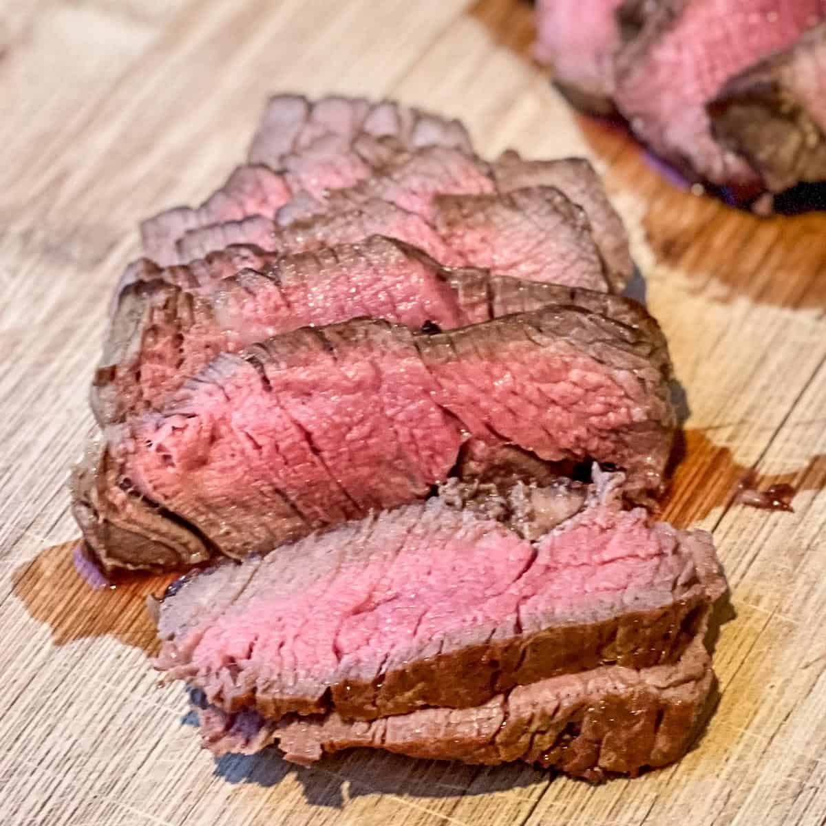 Filet Mignon steak sliced and showing perfect medium rare interior.