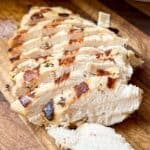 Sliced grilled chicken on a cutting board.