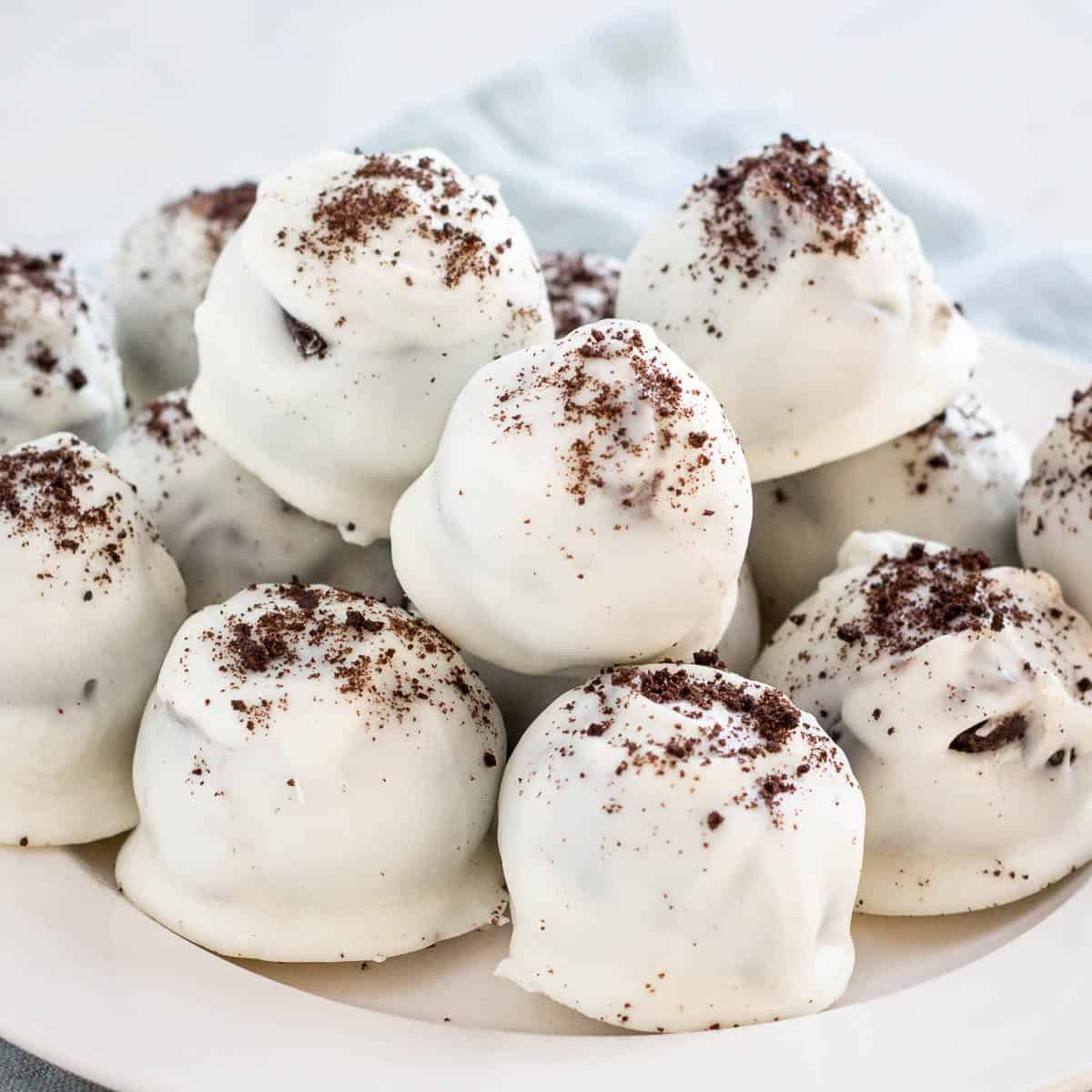 No Bake Oreo Balls covered in white chocolate and crushed oreo sprinkles.