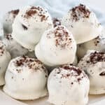 No Bake Oreo Balls covered in white chocolate and crushed oreo sprinkles.