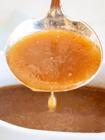 Simple Pan Gravy dripping from a ladle into a gravy boat full of gravy.