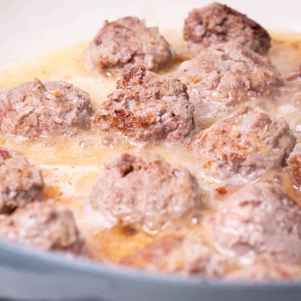 Bison Meatballs simmering in gravy.