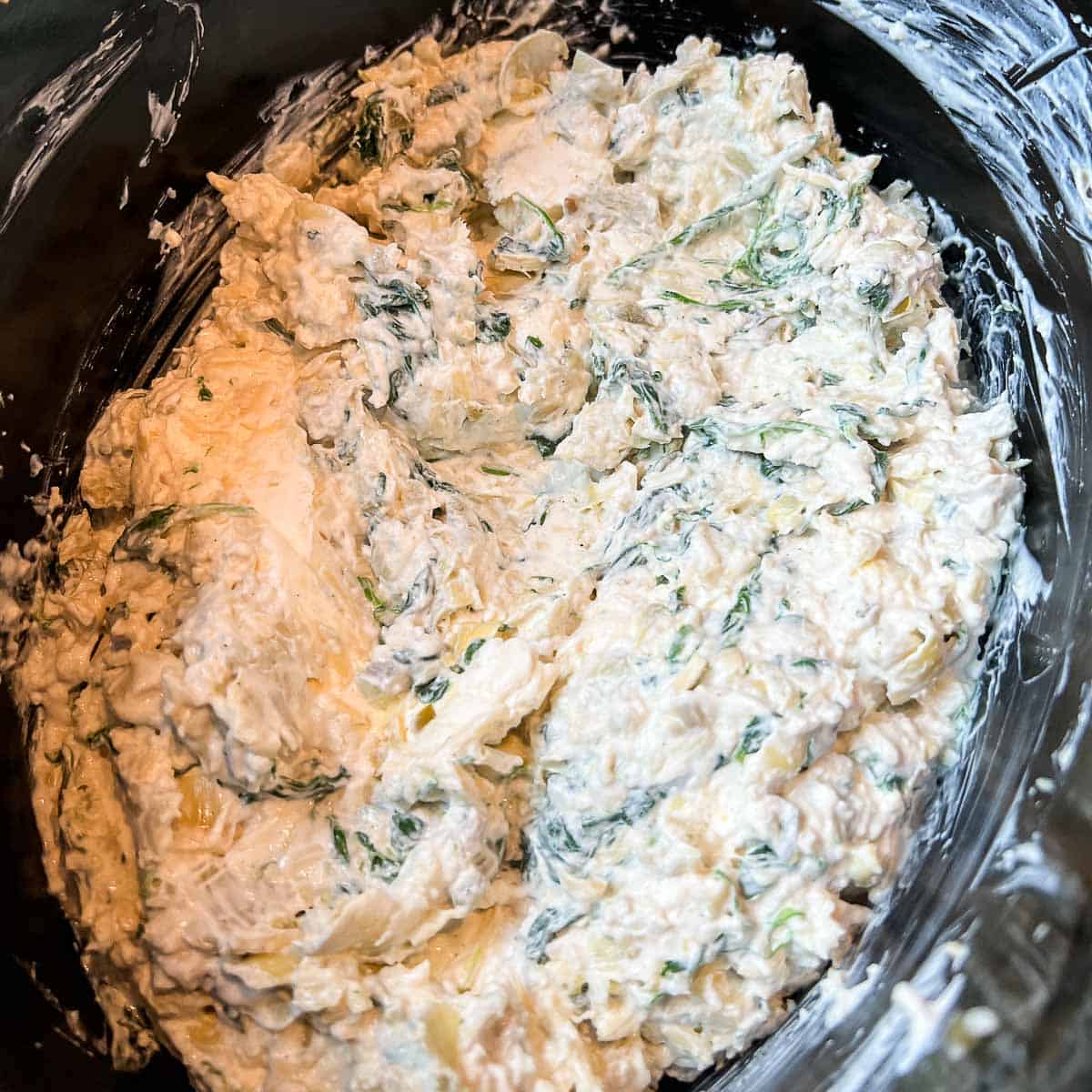 Ingredients for Spinach Artichoke Dip Recipe mixed together in a crockpot.