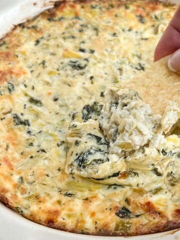 Chip dipped into spinach artichoke dip.