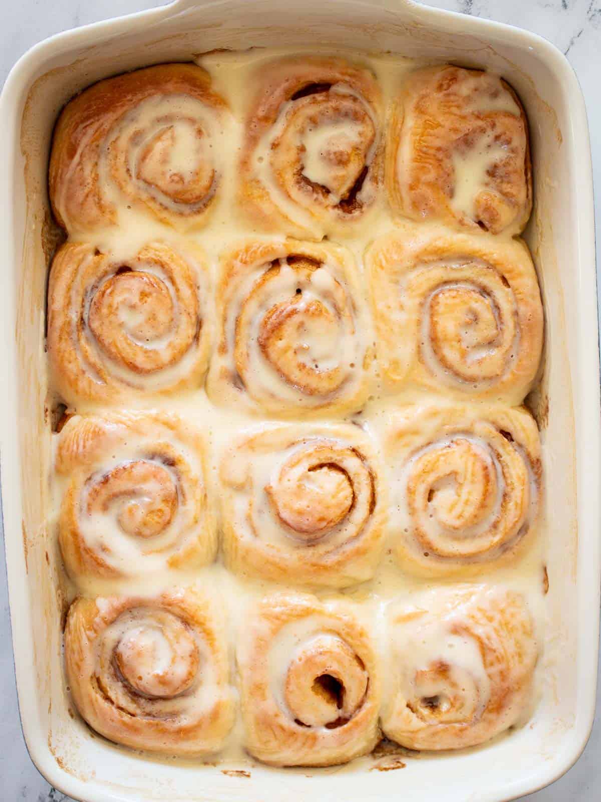 A whole pan of cinnamon rolls with icing.