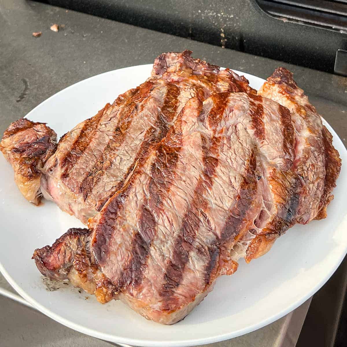 Grilled ribeye steaks just taken off the grill to rest.