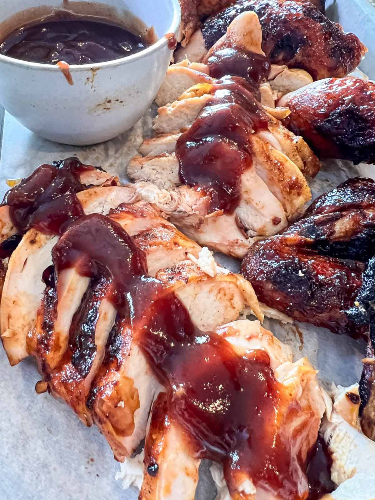 Grilled beer can chicken carved and arranged on a serving platter.