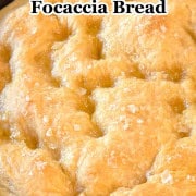 A whole baked focaccia in a cast iron skillet.