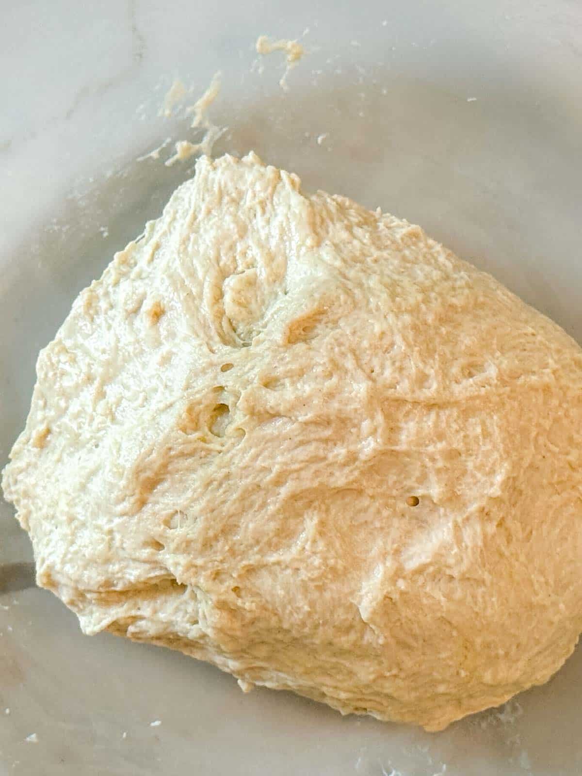 A shaggy focaccia dough mixed together with white background.