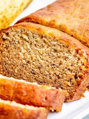 A loaf of banana bread on a white plate.
