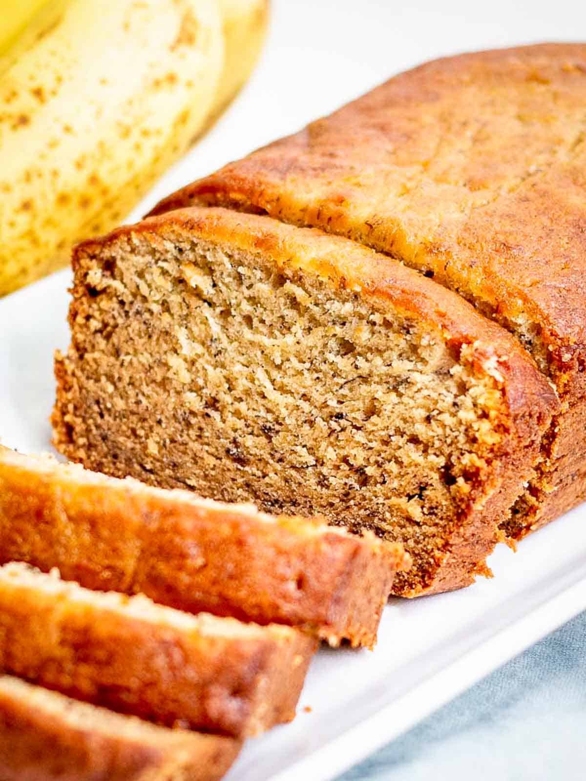 A loaf of banana bread on a white plate.