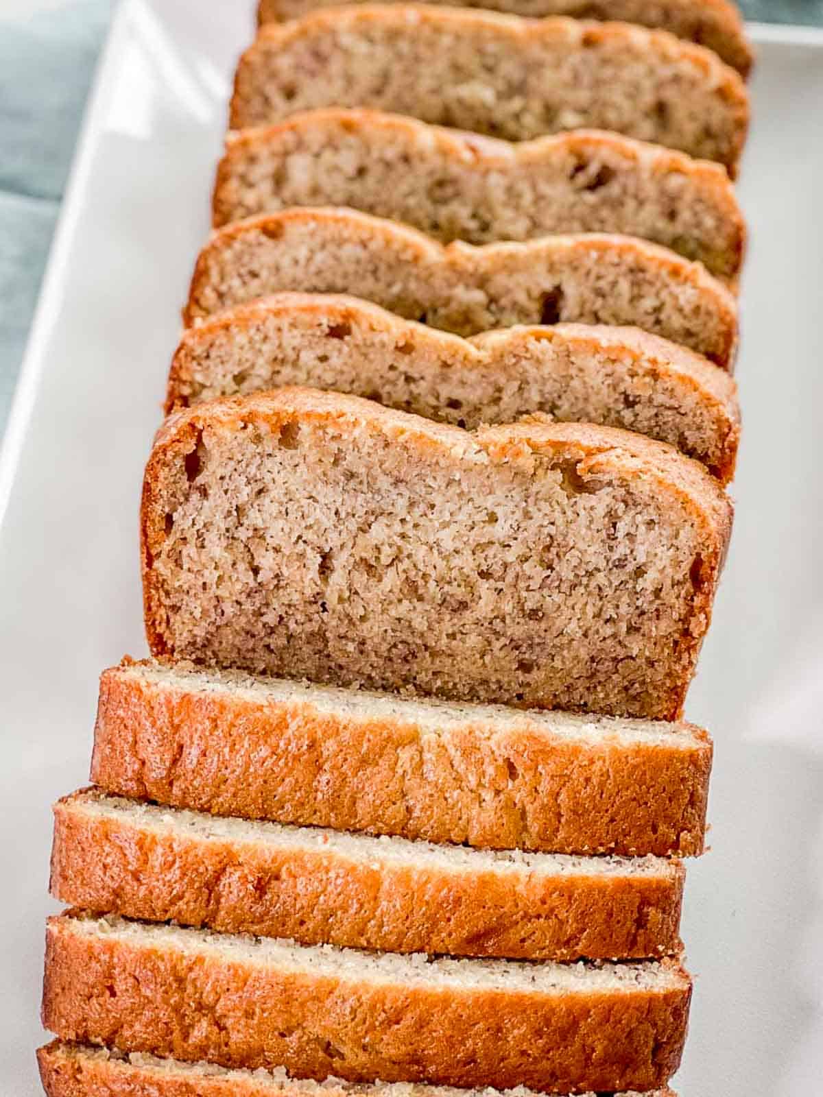 A loaf of banana bread is sliced into slices.