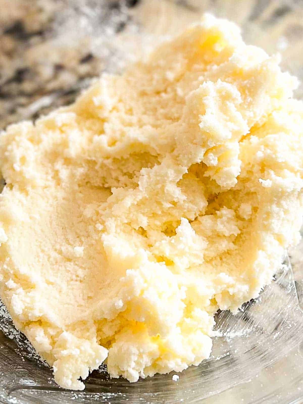 A bowl of creamed butter and sugar sitting on top of a counter.