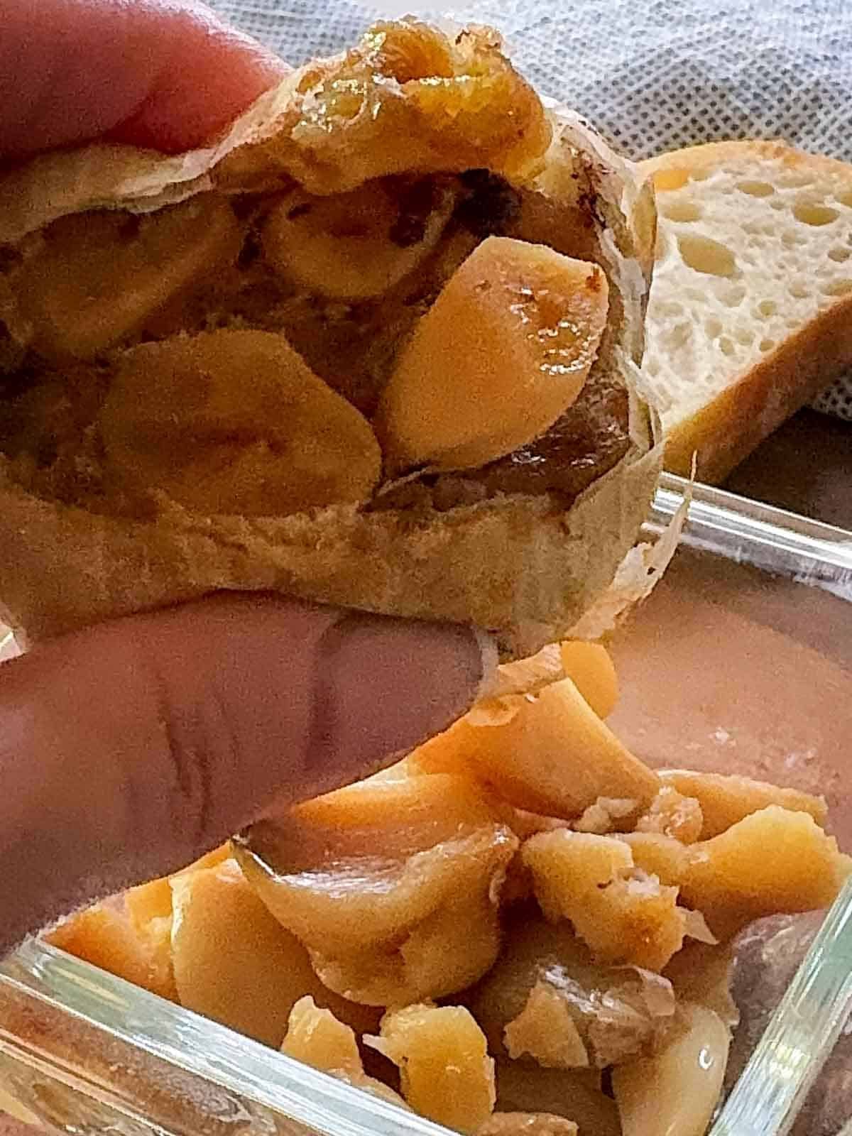 Close-up of roasted garlic cloves squeezed from skin onto small dish.