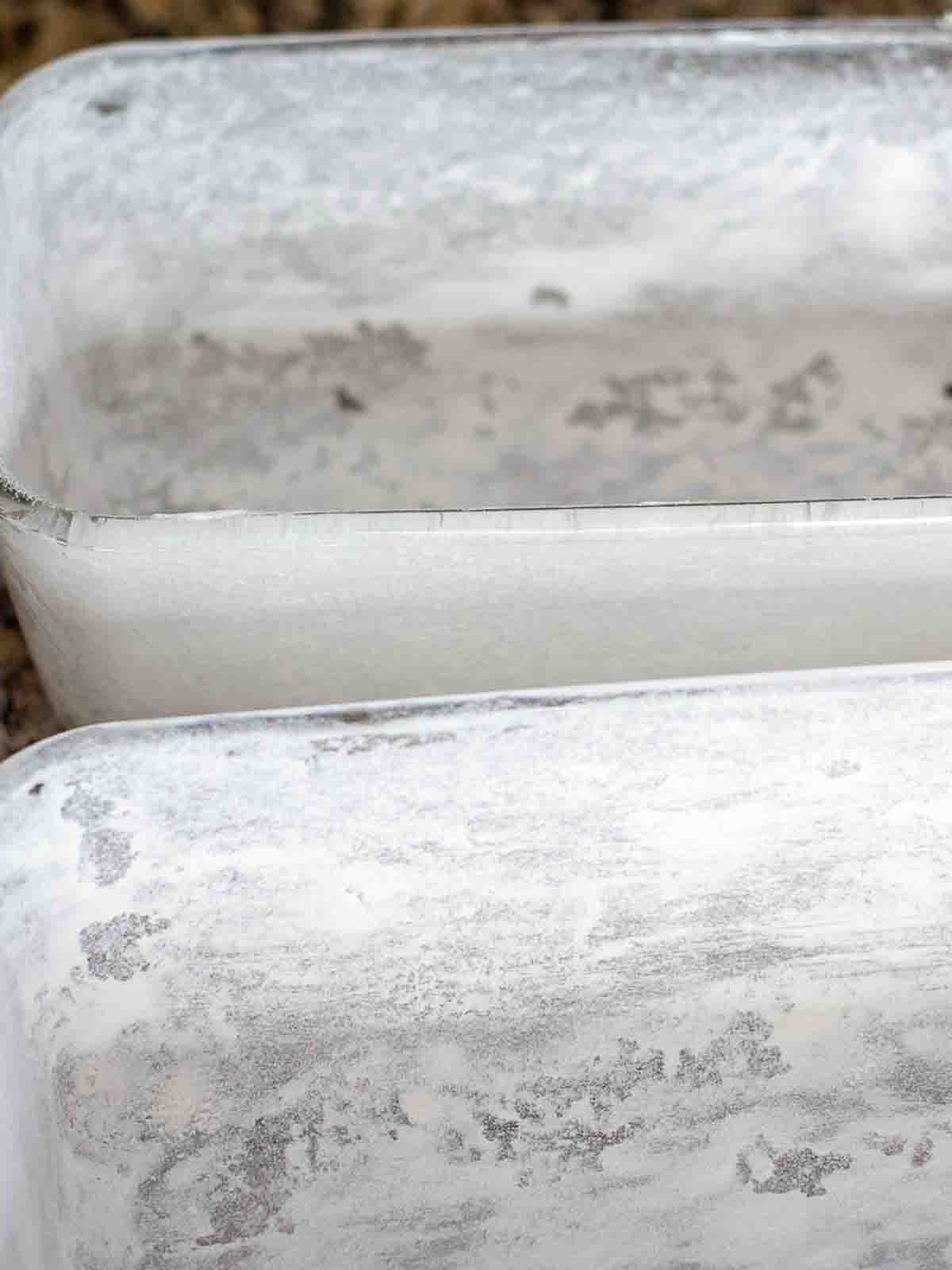 Glass pans that have been greased and floured for pumpkin bread recipe.