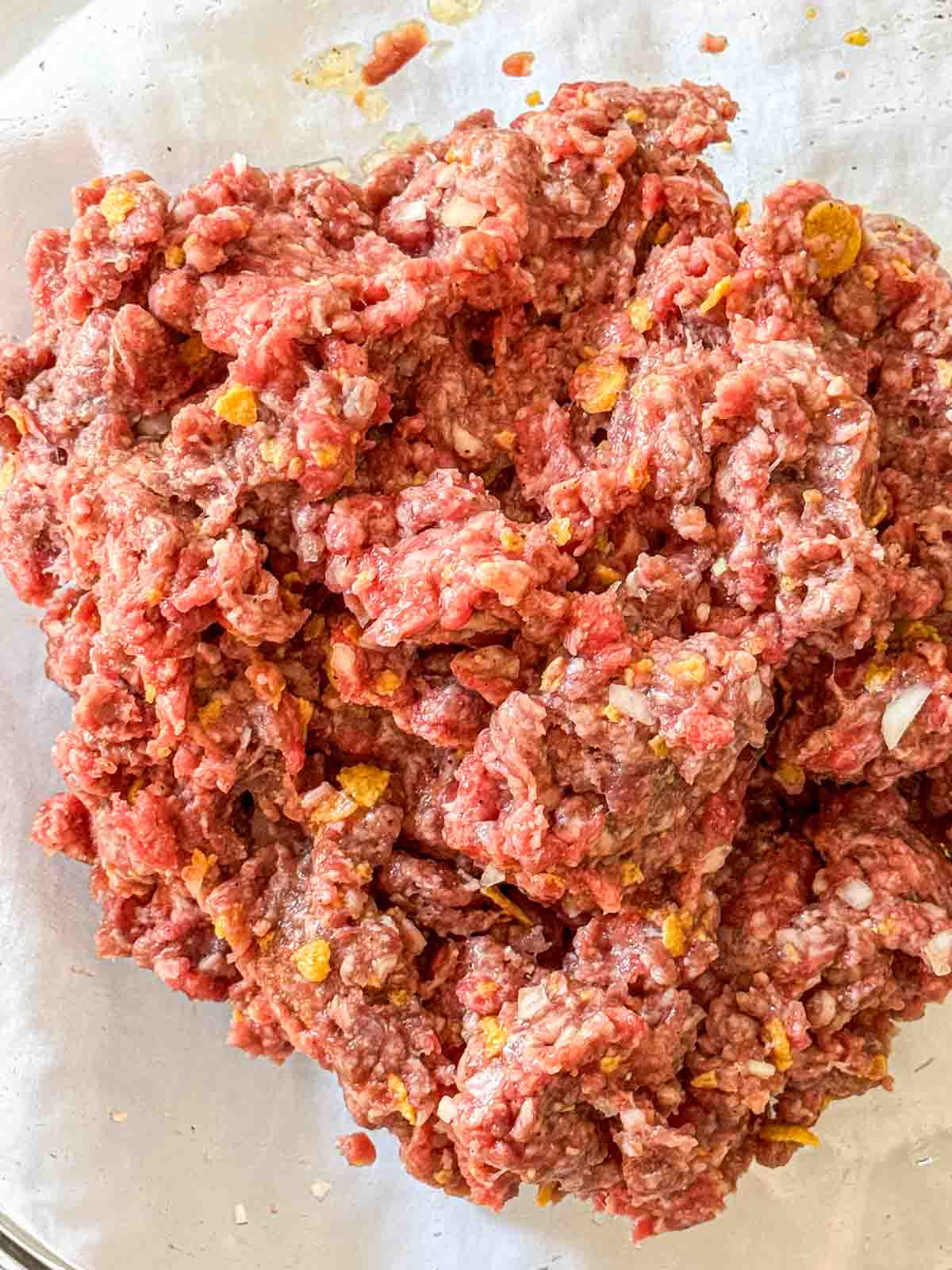 Meatloaf ingredients mixed together in a glass bowl.