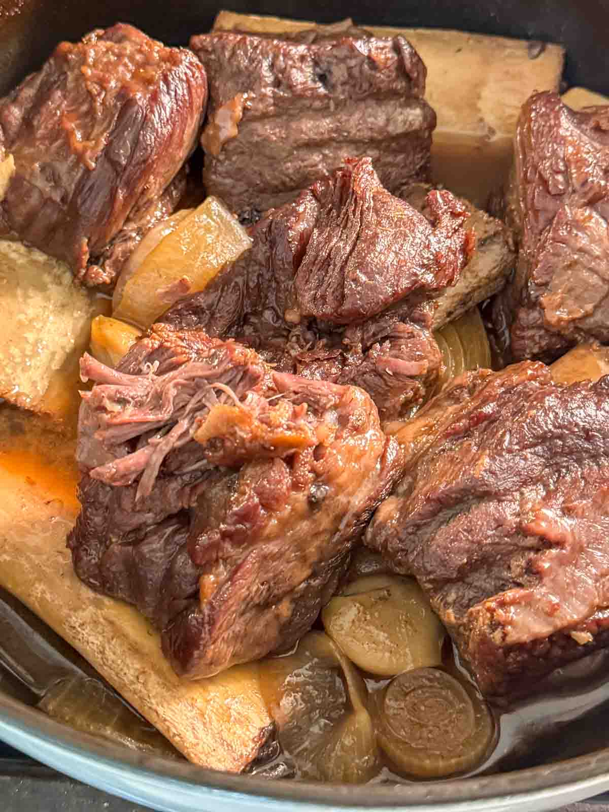Braised short ribs served in a Dutch oven with rich pan juices.