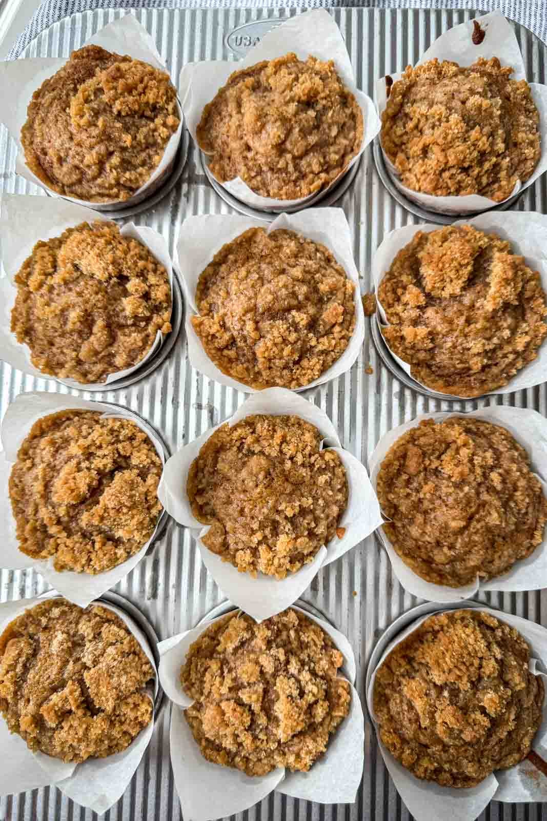 Baked pumpkin streusel muffins with set tops and golden brown crumb topping.