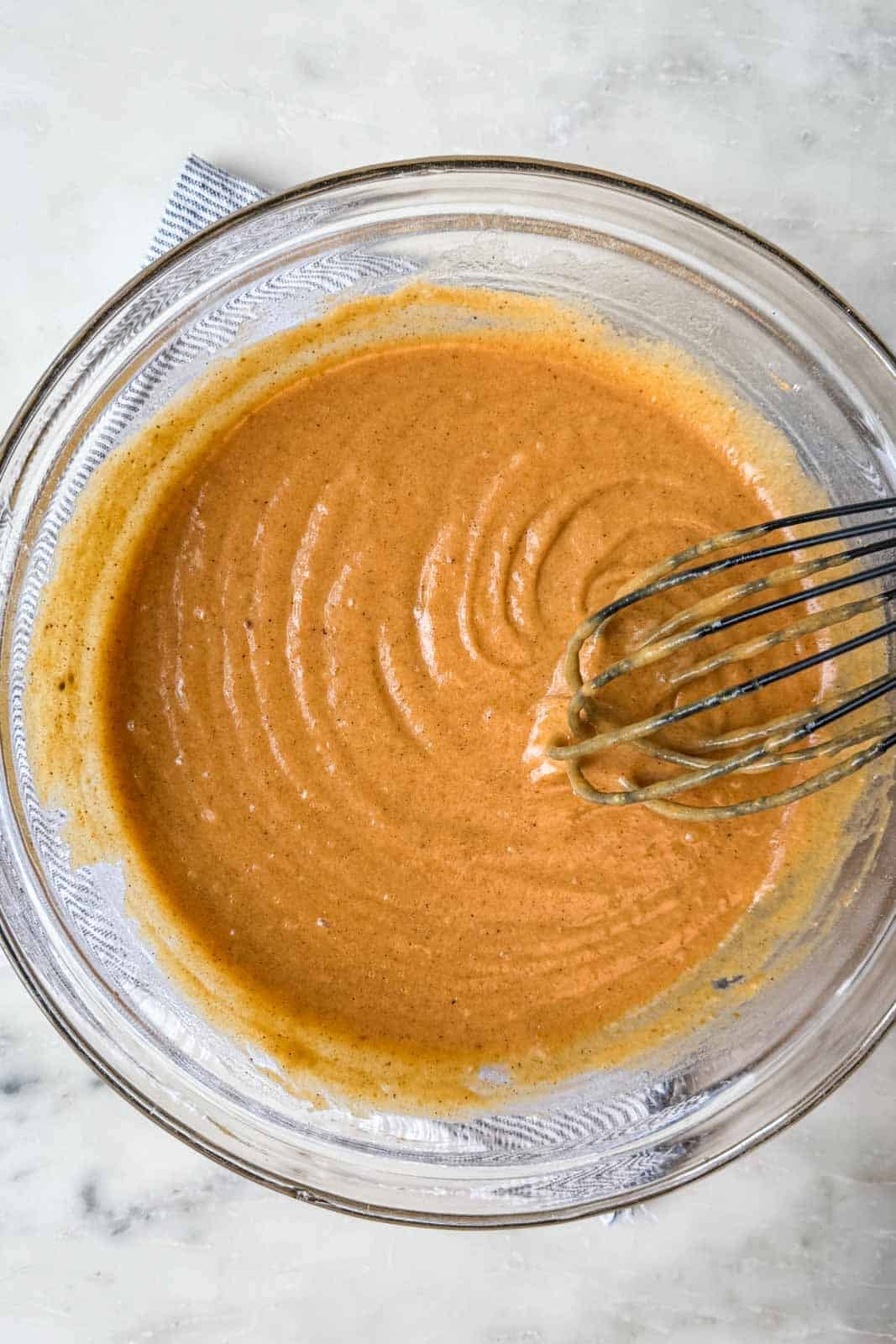 Pumpkin muffin batter gently stirred by hand until no streaks of flour remain.