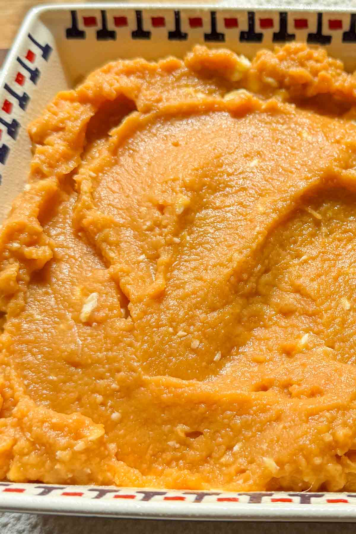 Creamy sweet potato casserole filling spread evenly in a baking dish.