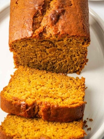 Sliced homemade pumpkin bread displayed on a serving plate.