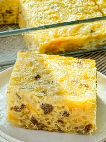 Sausage hash brown breakfast casserole with a generous slice plated.