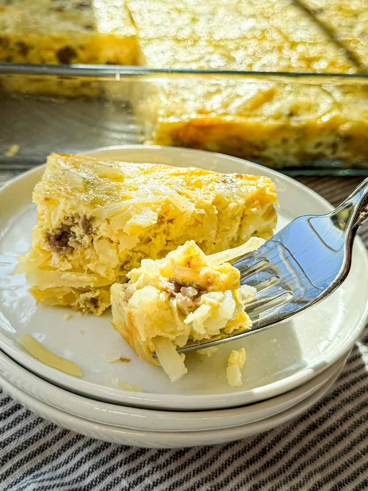 A forkful of sausage, eggs, shredded hash browns, and melted cheddar.