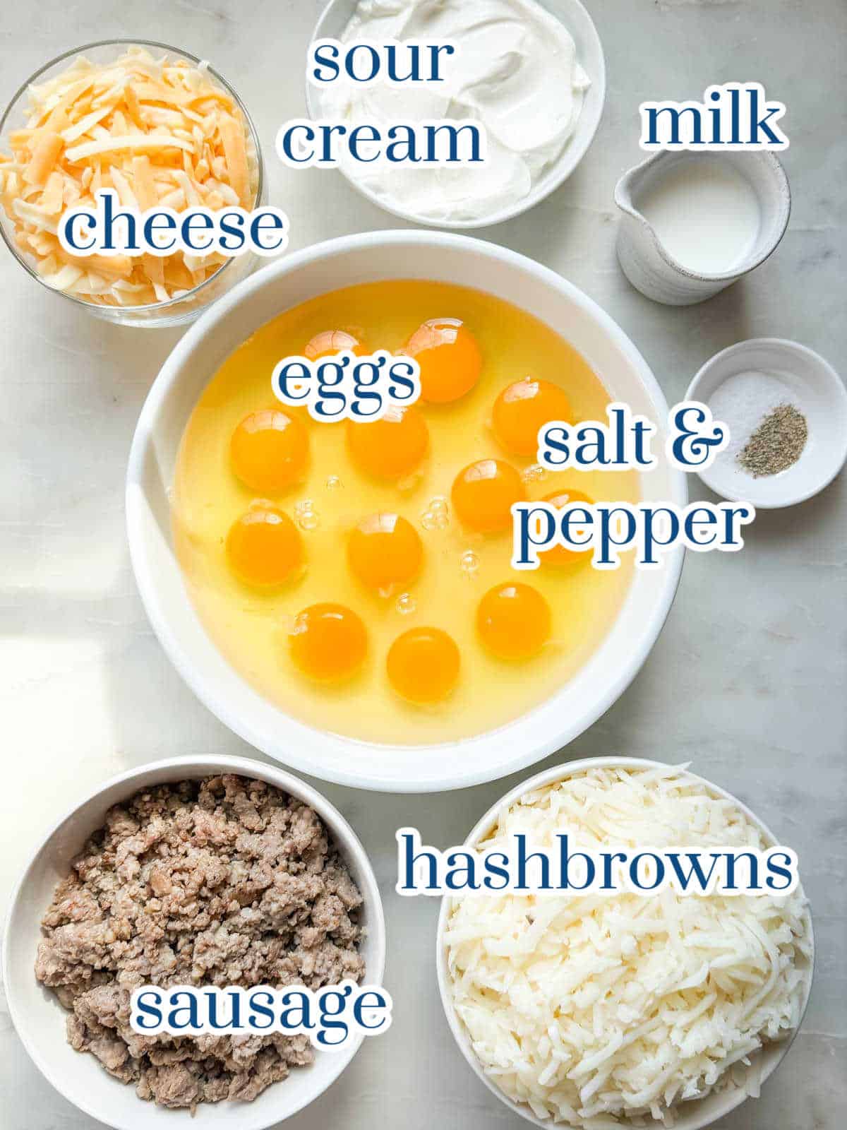 Ingredients for sausage hash brown breakfast casserole arranged on a counter.