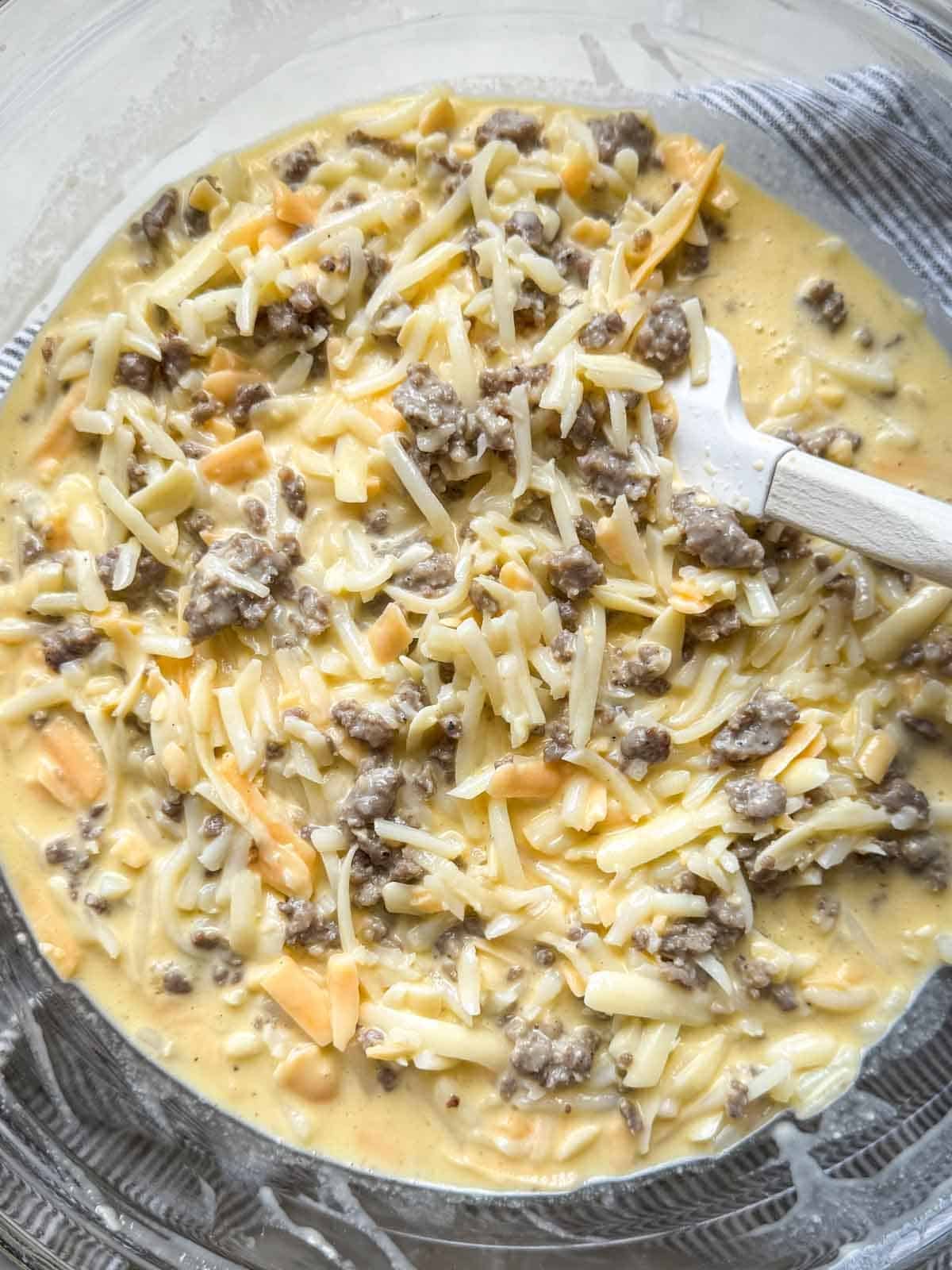 Cooked sausage, shredded hash browns, and cheddar mixed into the egg mixture.